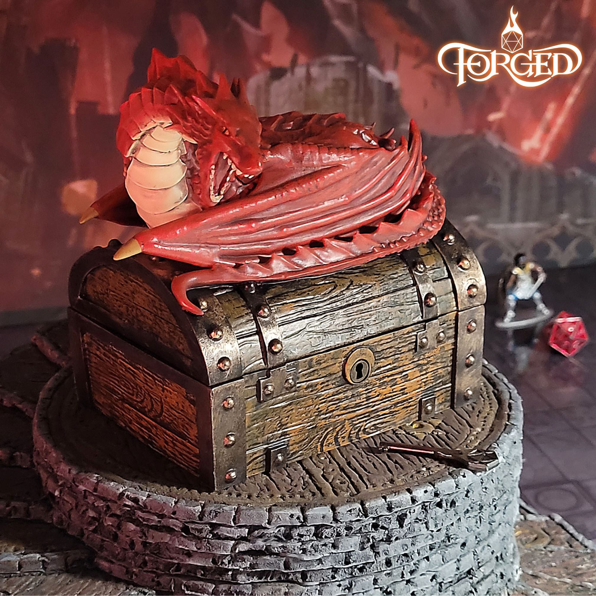This is an environmental image of the Red colored Forged Gaming Wyvern Dice Chest sitting on a piece of gaming terrain.