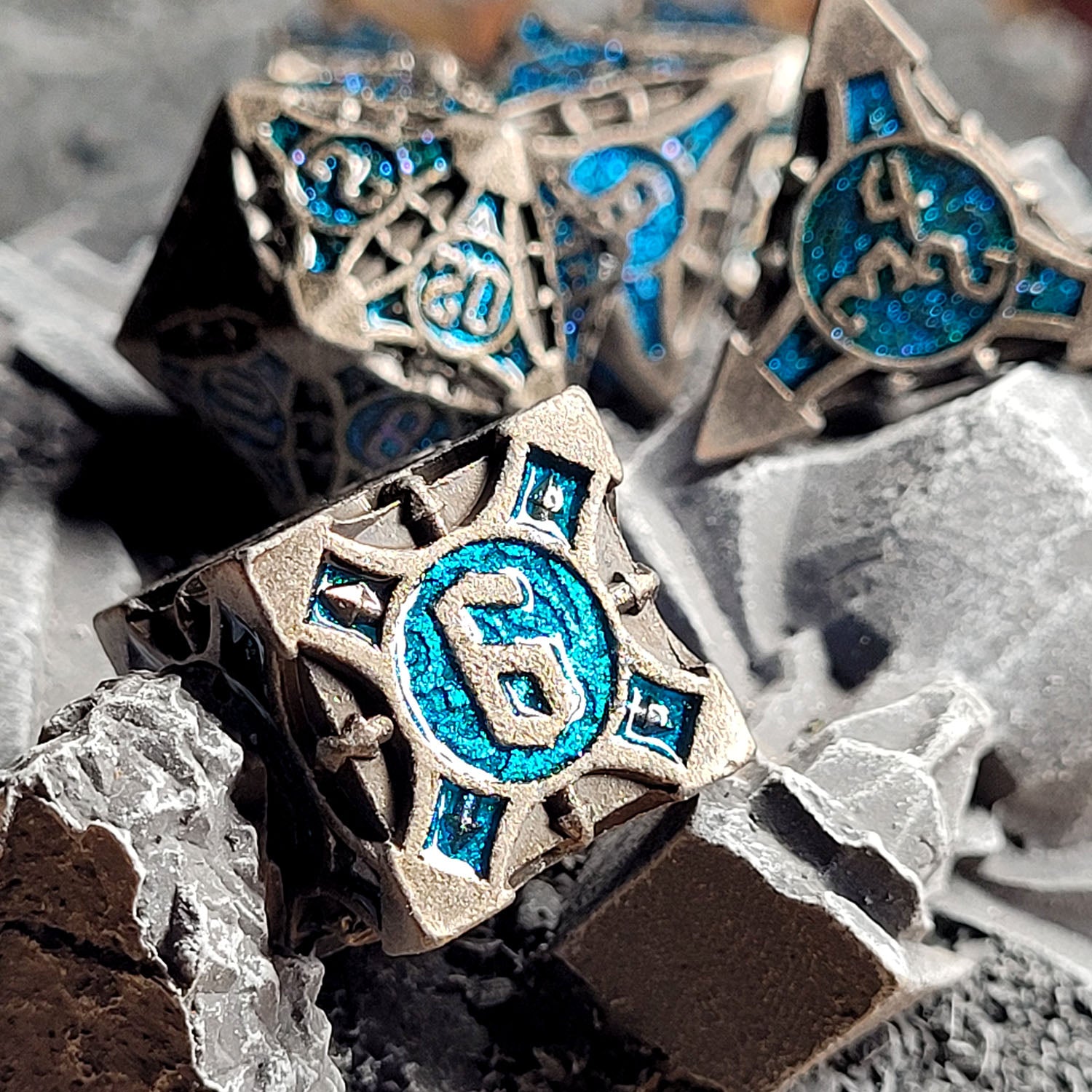 This is an environmental image of the Forged Gaming Arcane Enigma Iron Blue Metal RPG Dice Set. The photo was taken using stone wargaming terrain as a background.