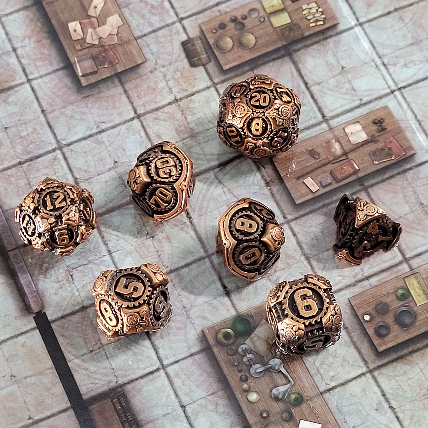 This is an environmental image of the Forged Gaming Chronomica Mechanicum Gold Metal RPG Dice Set. This photo was taken using a game board as a background.