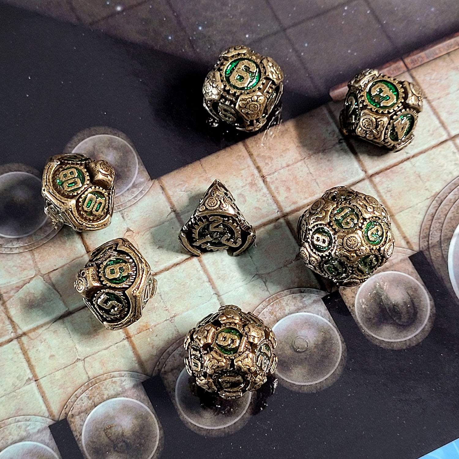 This is an environmental image of the Forged Gaming Chronomica Mechanium Gold Green Metal RPG Dice Set. This photo was taken using a game board as a background.