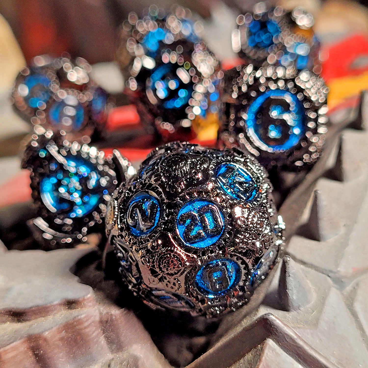 This is an environmental image of the Forged Gaming Chronomica Mechanicum Gunmetal Blue Metal RPG Dice Set. This image was taken using wargaming terrain as a background.