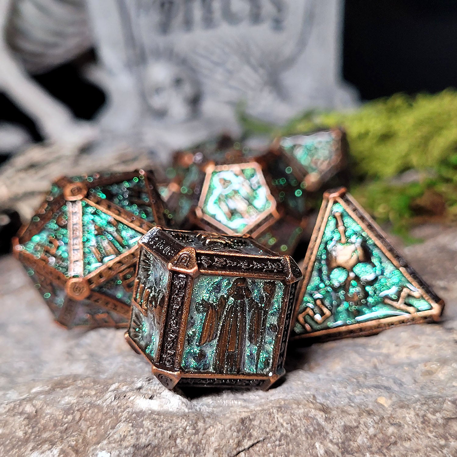 This is an environmental image of the Forged Gaming Cryptic Reliquary Shimmering Green Metal RPG Dice Set. The photo was taken against the backdrop of a piece of stone wargaming terrain.