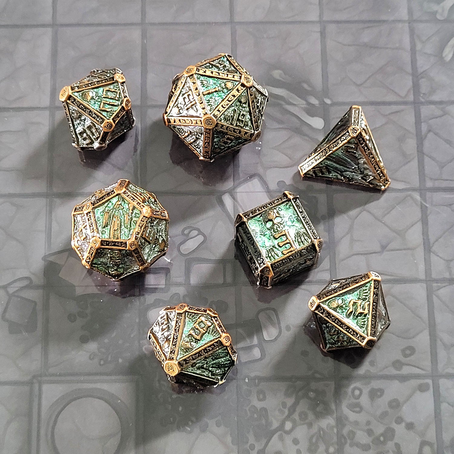 This is an environmental image of the Forged Gaming Cryptic Reliquary Shimmering Green Metal RPG Dice Set. The photo was taken against the background of  Dungeon Floor Encounter Map.