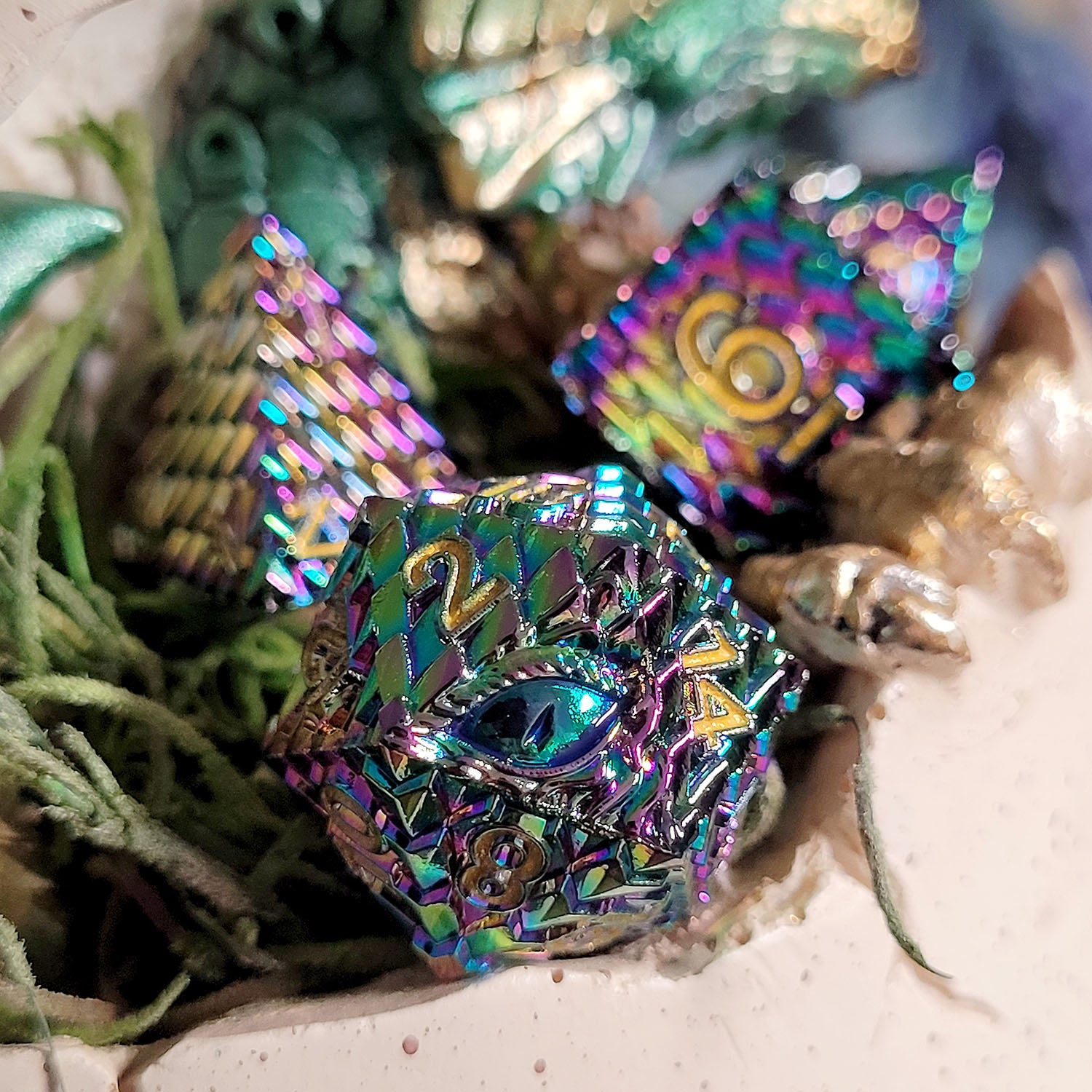 This is an environmental image of the Forged Gaming Dragon's Gaze metal RPG dice set. The image was taken using an open dragon egg as a background.