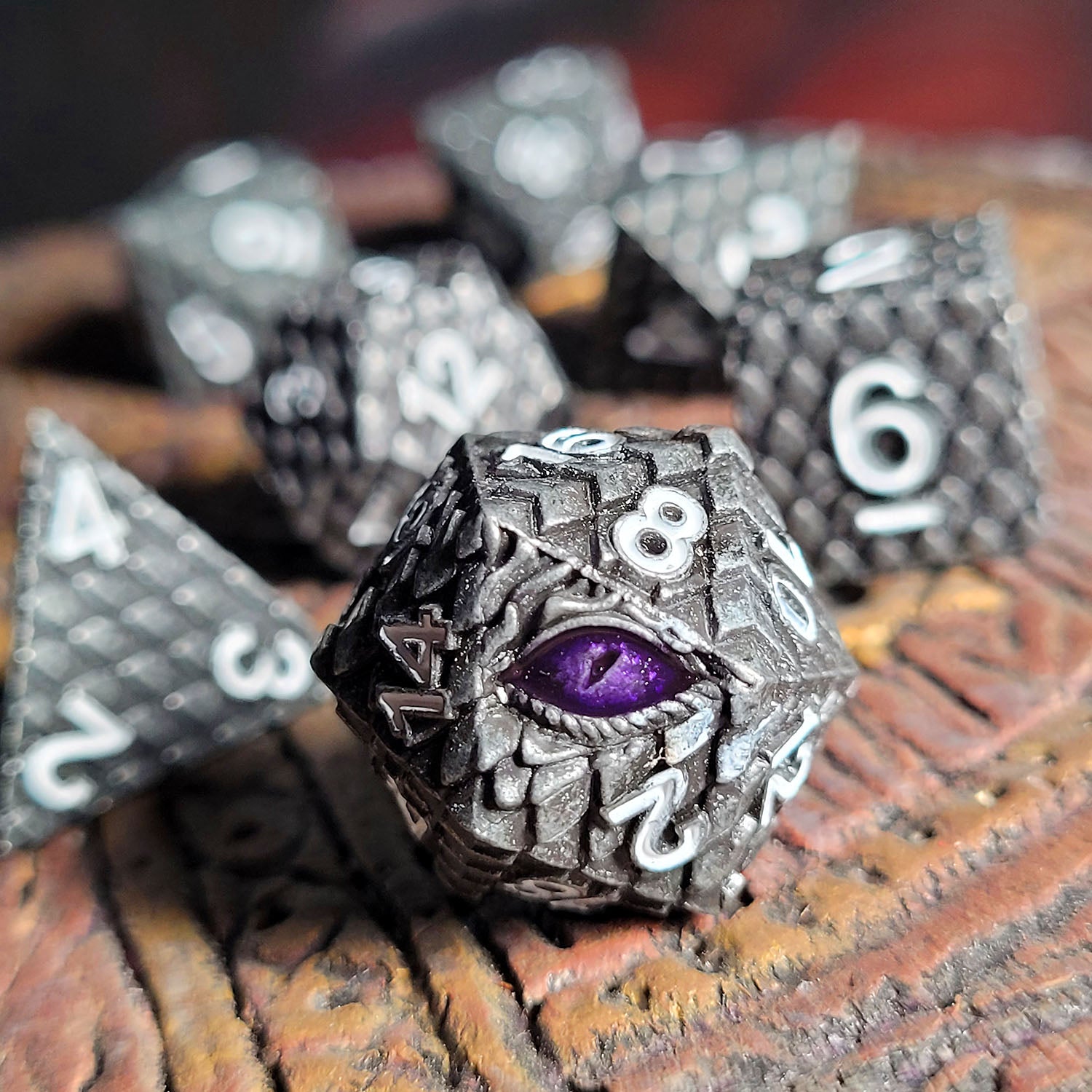 This is an environmental image of the Forged Gaming Dragon's Gaze Silver Metal RPG Dice Set. The photo was taken using a piece of temple wargaming terrain.