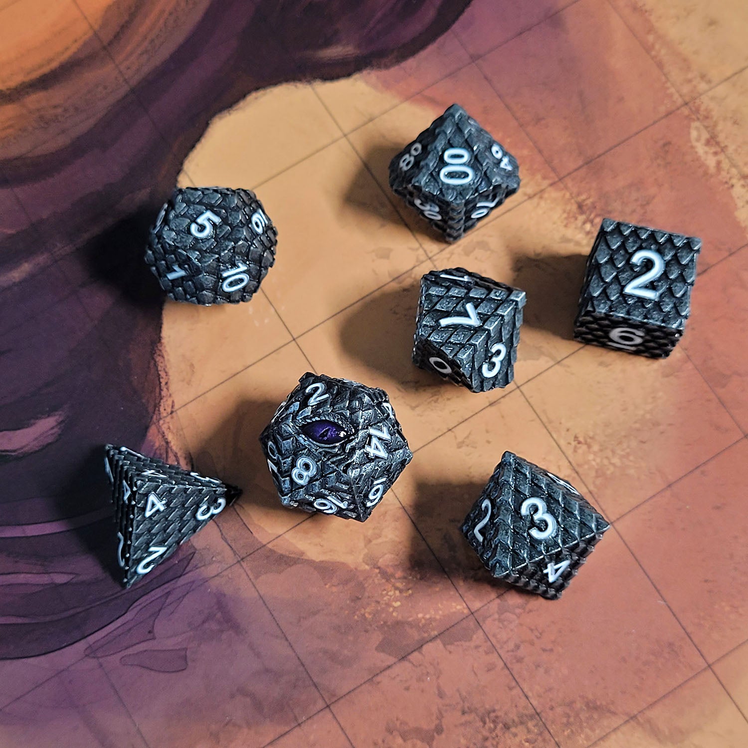 This is an environmental image of the Forged Gaming Dragon's Gaze Silver Metal RPG Dice Set. The photo was taken using the Desert Sands Encounter Map as a background.