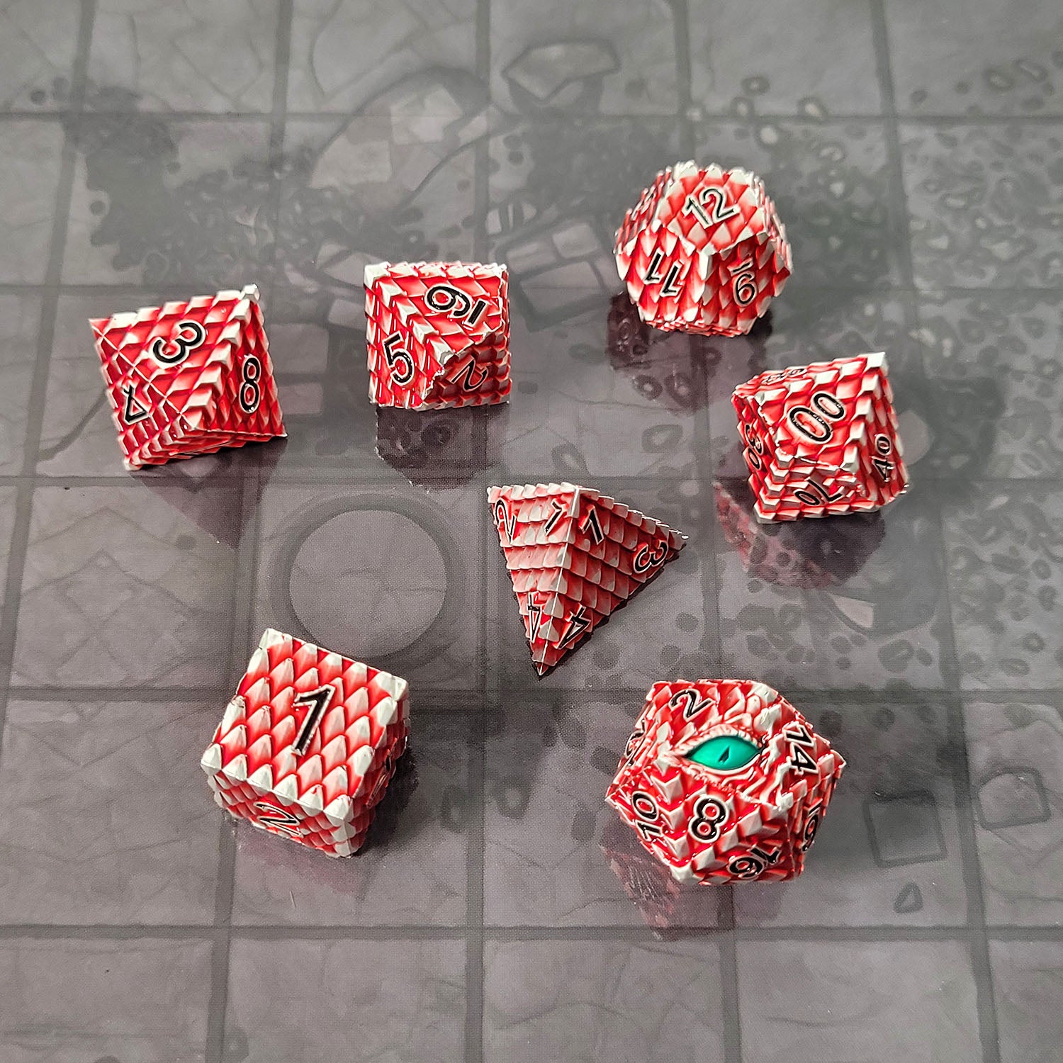 This is an environmental image of Forged Gaming's Dragon's Gaze Silver Red Metal RPG Dice Set. The photo was taken using the Dungeon Floor Encounter Map as a background.