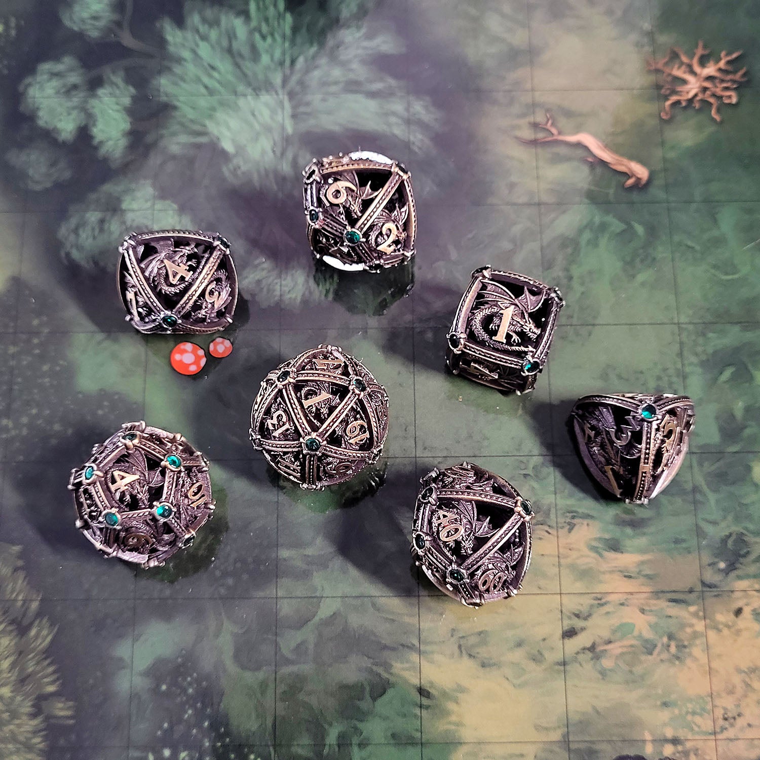 This is an environmental image of the Forged Gaming Dragon's Jewel Ancient Gold Hollow Metal RPG Dice Set. The photo was taken using the Wooded Forest Encounter Map as a background.