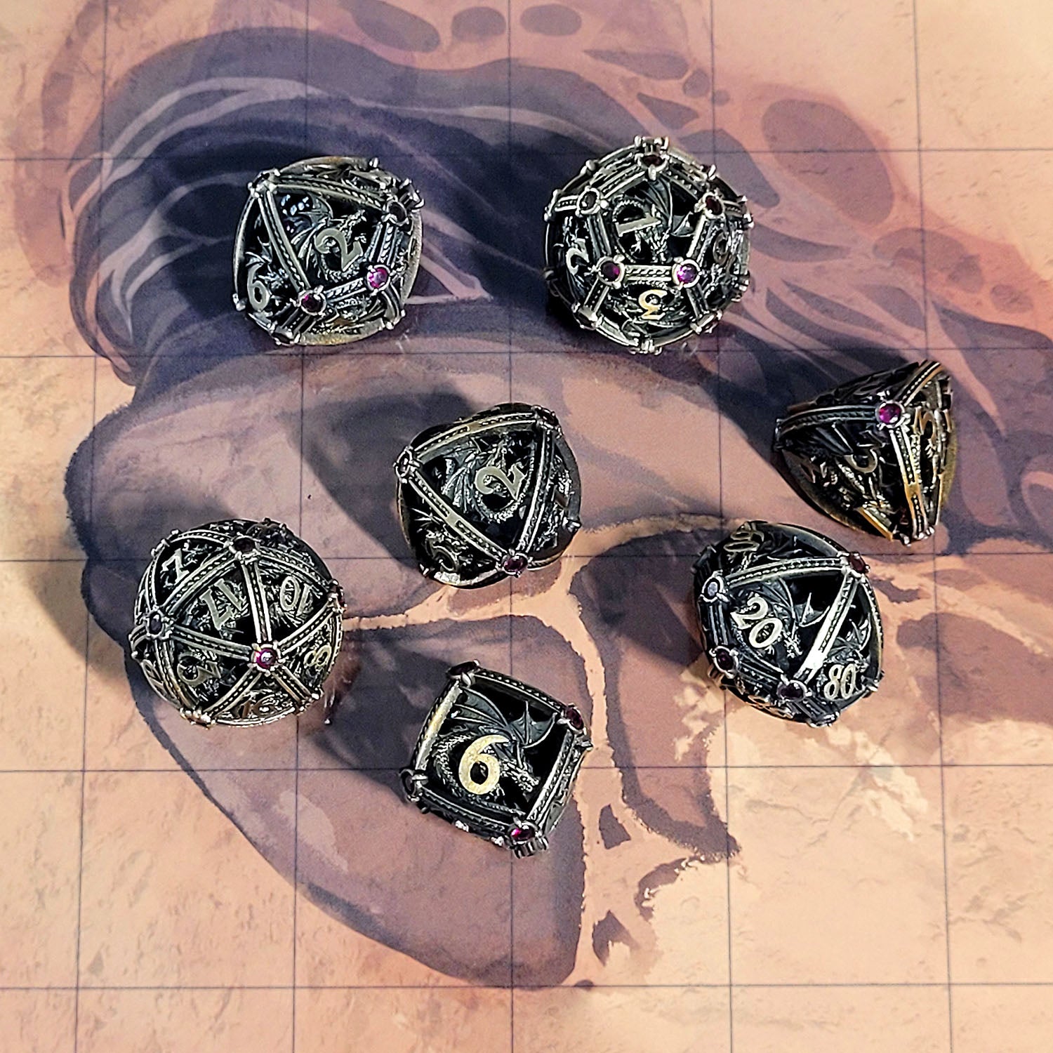 This is an environmental image of the Forged Gaming Dragon's Jewel Bronze Hollow Metal RPG Dice Set. The photo was taken using the Desert Sands Encounter Map as a background.