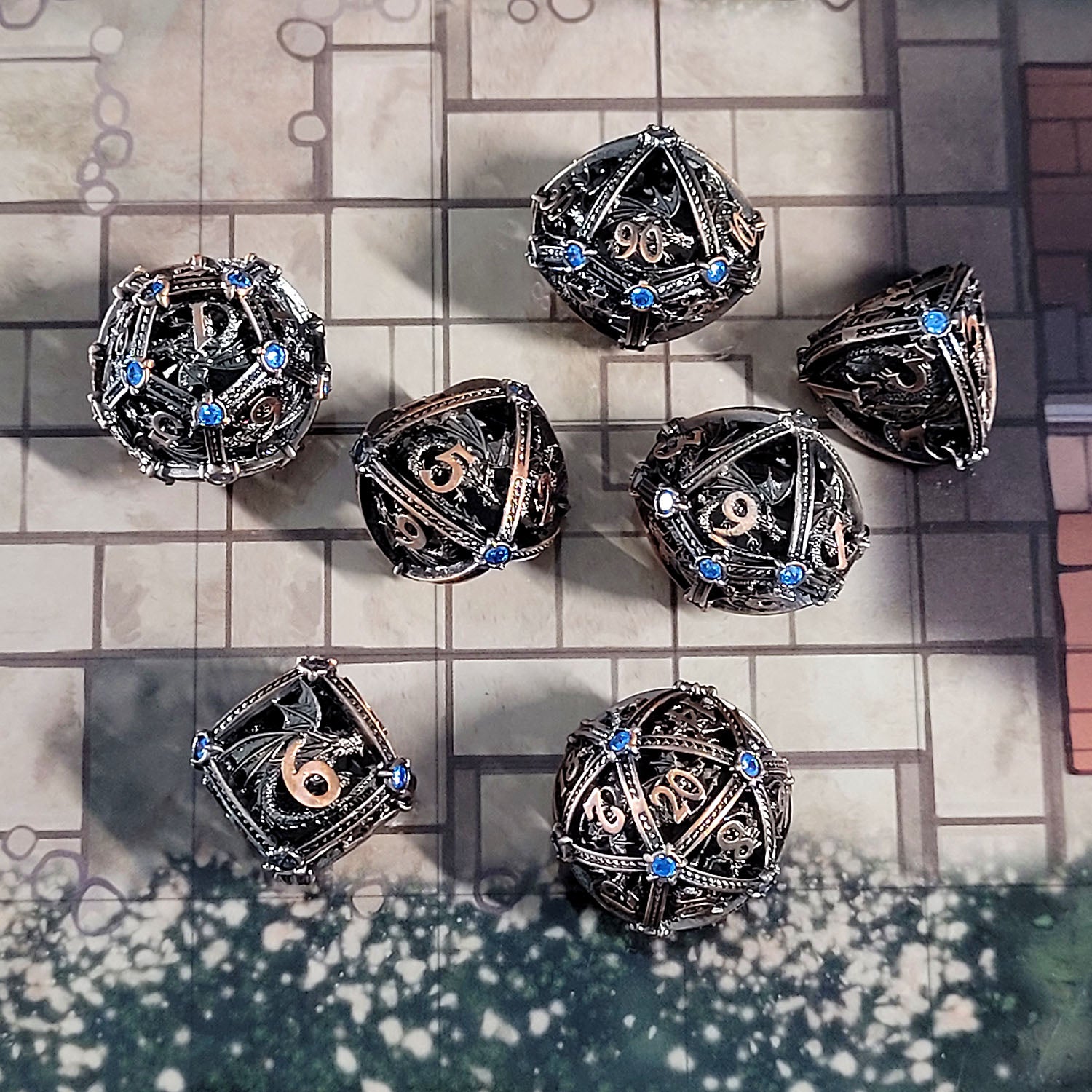 This is an environmental image of the Forged Gaming Dragon's Jewel Copper Hollow Metal RPG Dice Set. The photo was taken using the City Streets Encounter Map as a background.