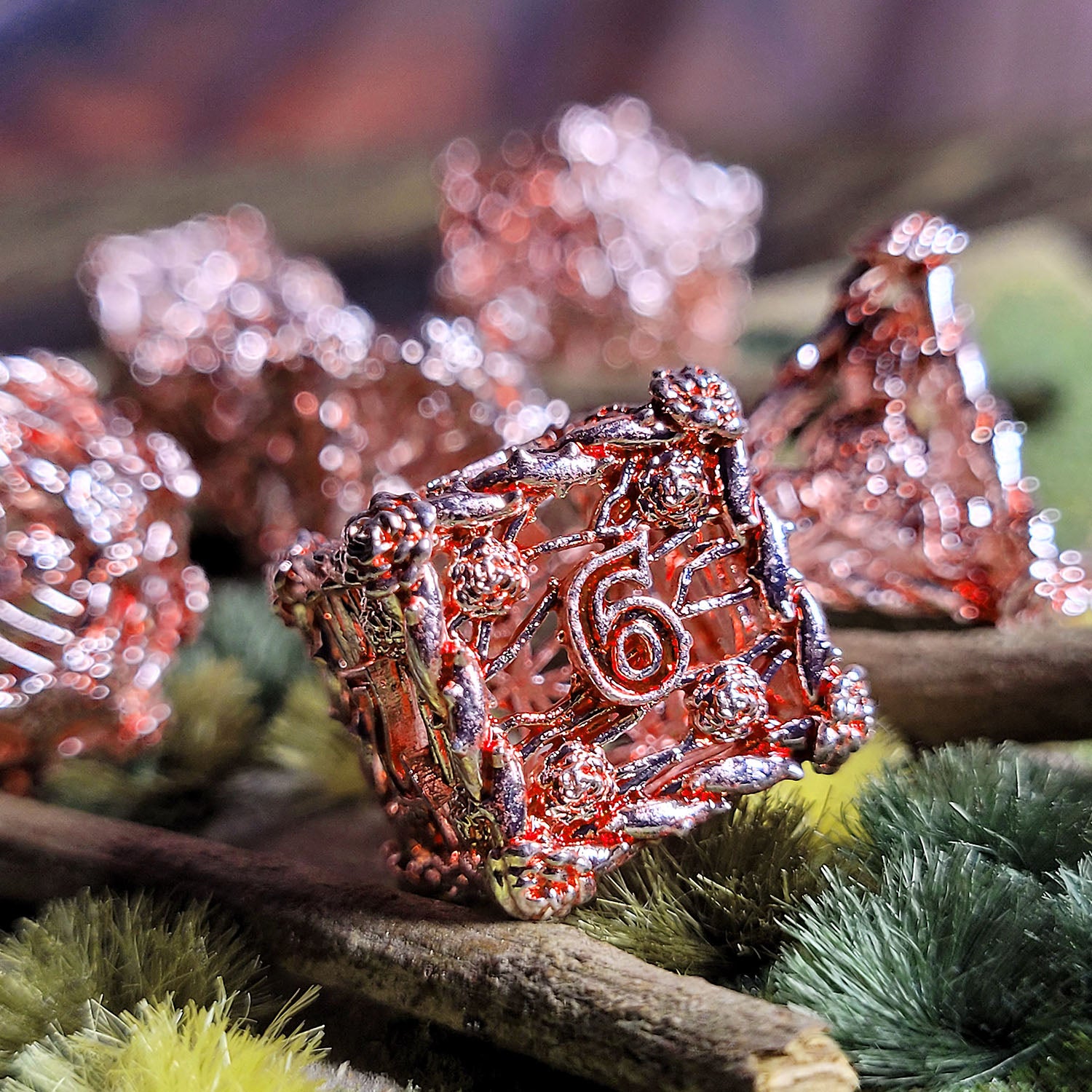 This is an environmental image of the Forged Gaming Enchanted Rose Silver Red Hollow Metal RPG Dice Set. The photo was taken using wargaming terrain as a background.