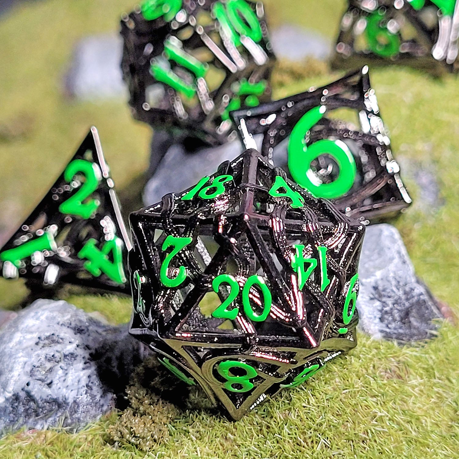 This is an environmental image of the Forged Gaming Entangled Fate Silver Green Hollow Metal RPG Dice Set. The photo was taken using a piece of wargaming terrain as a background.