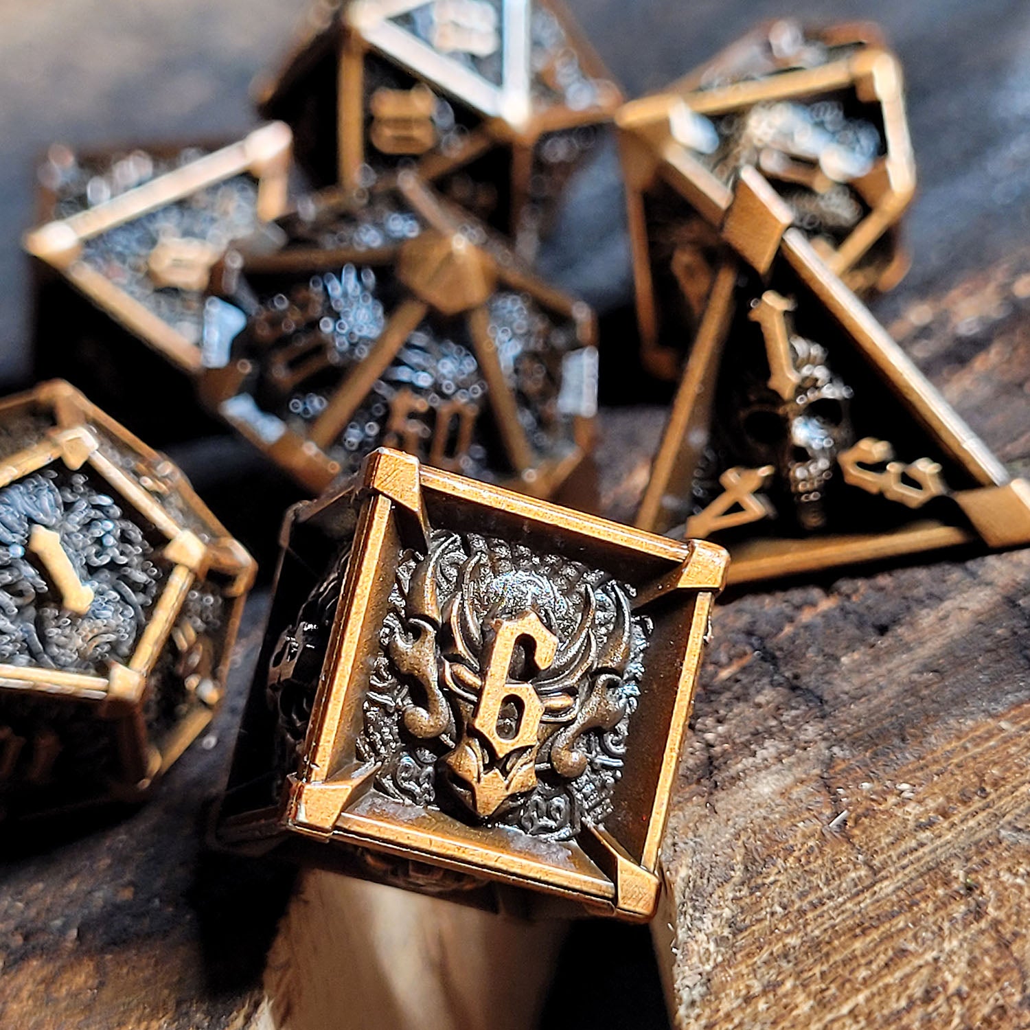 This is an environmental image of the Forged Gaming Ossuary Obscura Bronze Metal RPG Dice Set. The photo was taken using a scorched wood platform as a background.