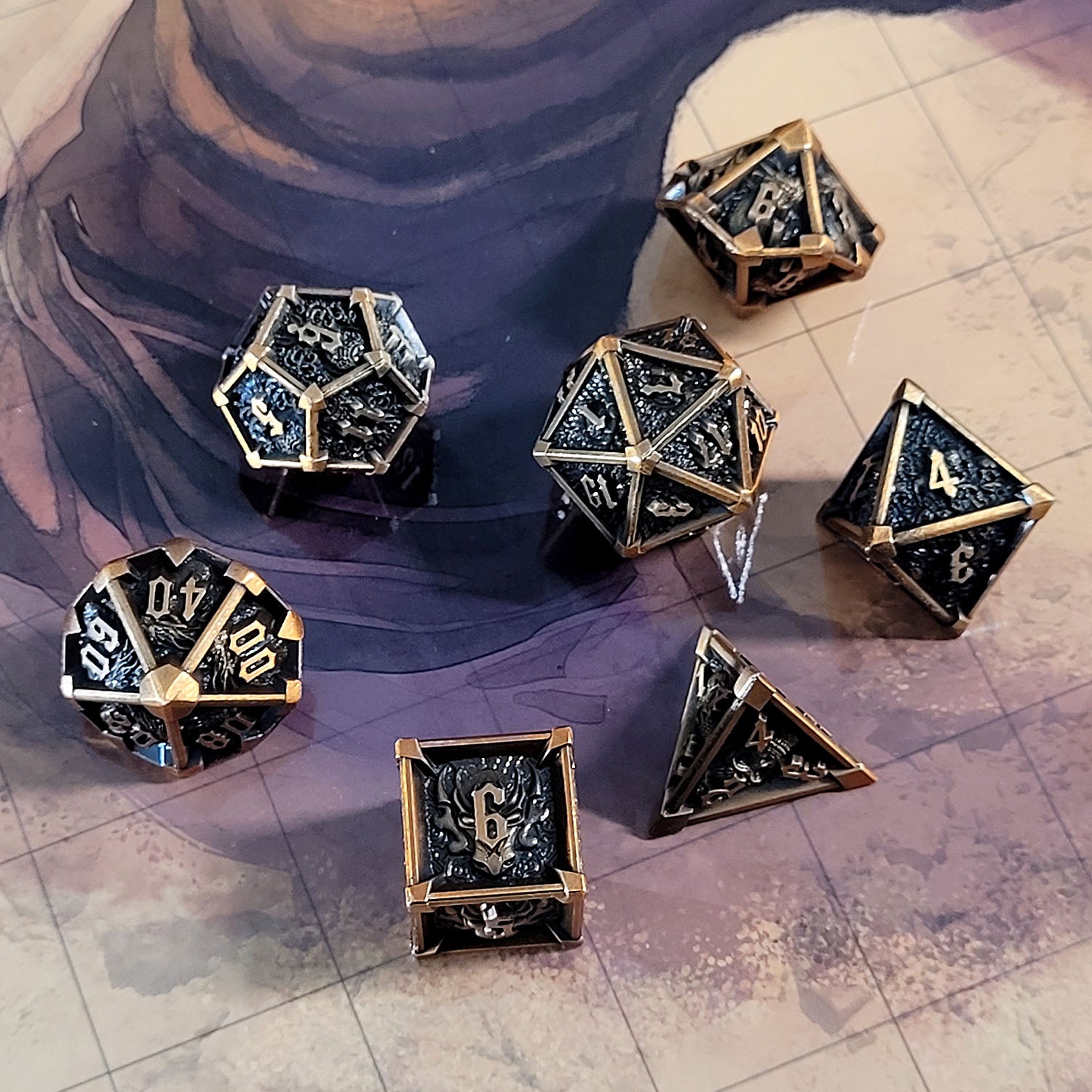 This is an environmental image of the Forged Gaming Ossuary Obscura Bronze Metal RPG Dice Set. The photo was taken using the Desert Sands Encounter Map as a background.