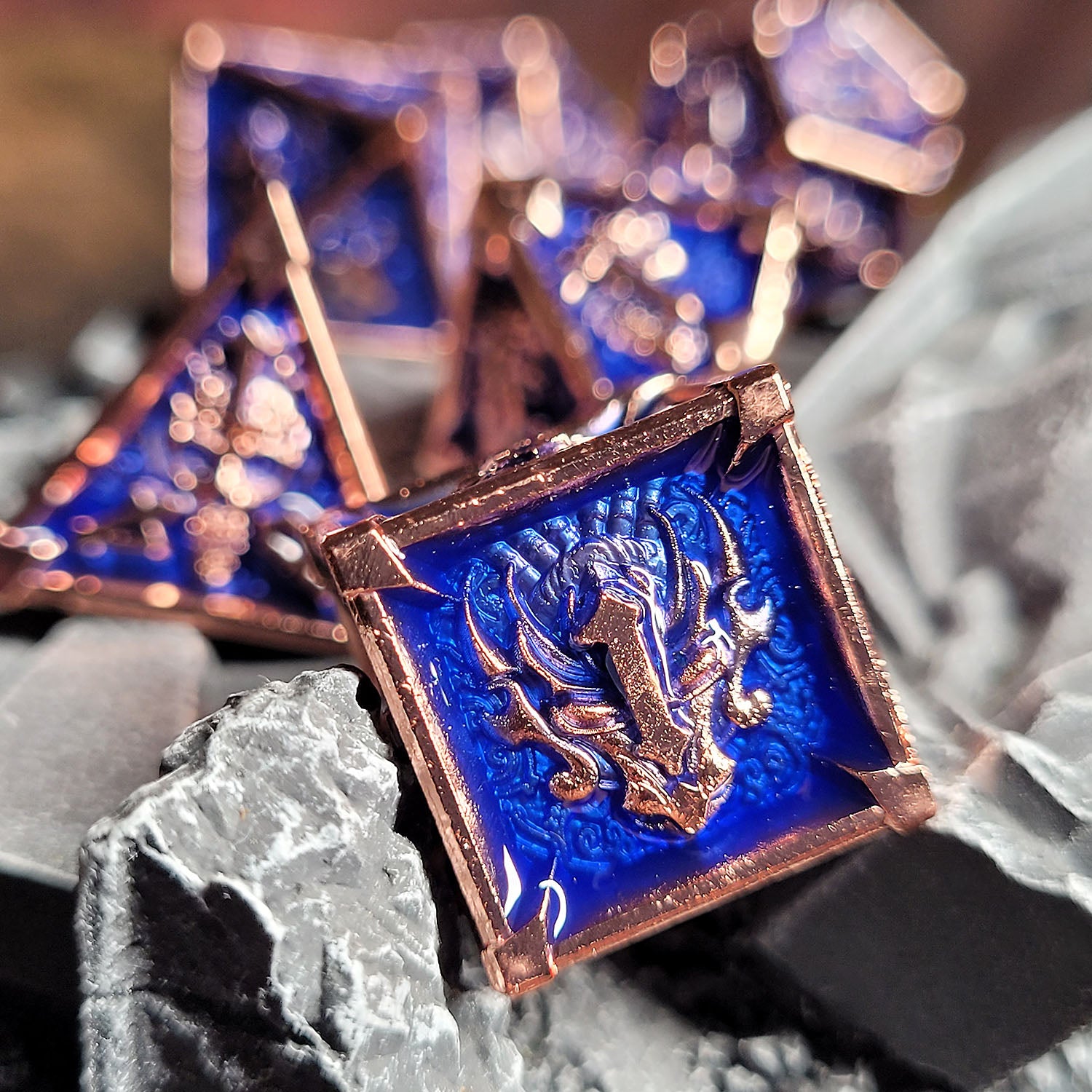 This is an environmental image of the Forged Gaming Ossuary Obscura Copper Blue Metal RPG Dice Set. The image was taken using stone wargaming terrain as a background.