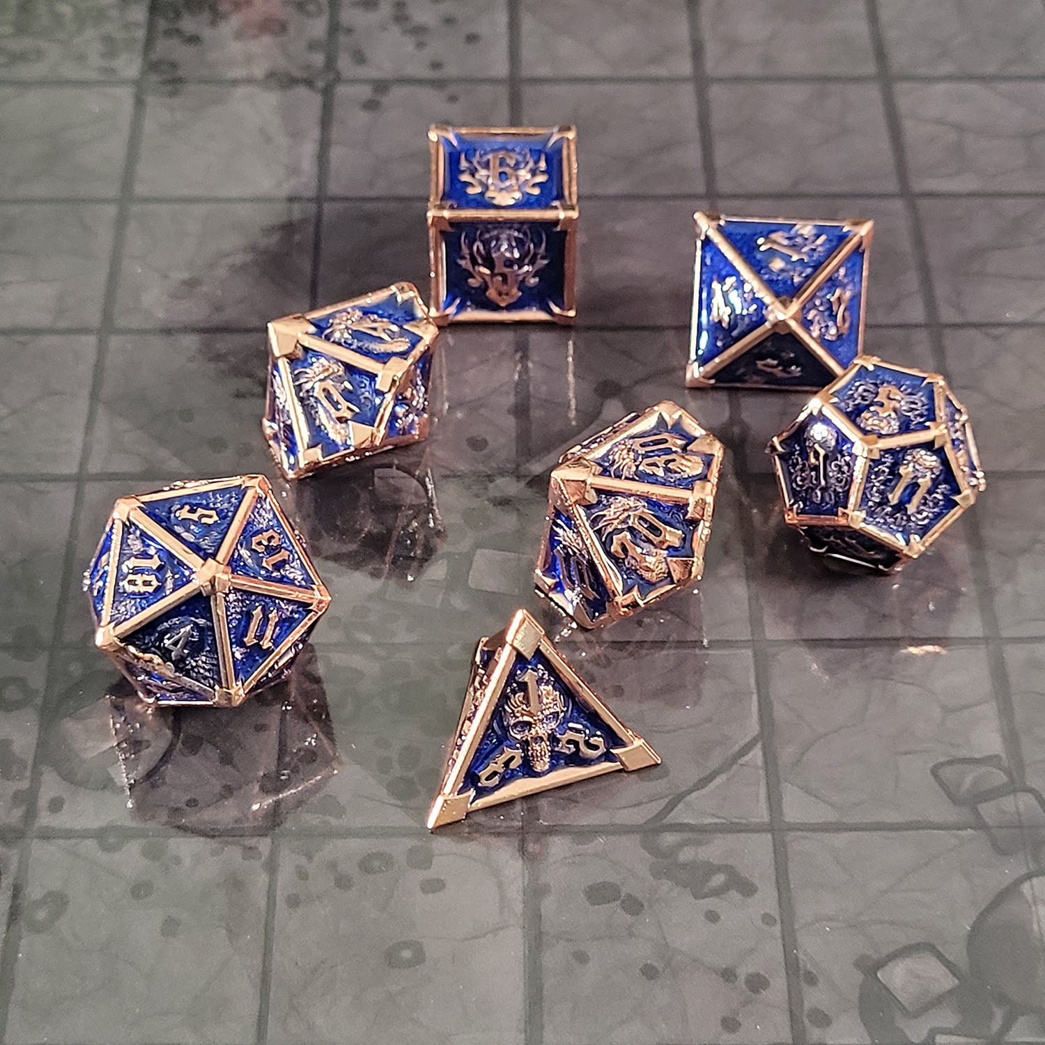 This is an environmental image of the Forged Gaming Ossuary Obscura Copper Blue Metal RPG Dice Set. The photo was taken using the Dungeon Floor Encounter Map as a background.