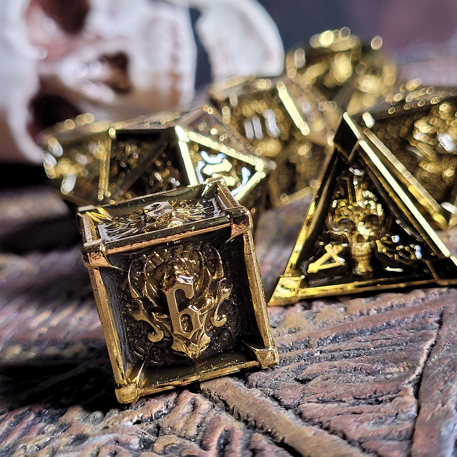 This is an environmental image of the Forged Gaming Ossuary Obscura Gold Metal RPG Dice Set. The photo was taken using a temple-themed piece of wargaming terrain as a background.