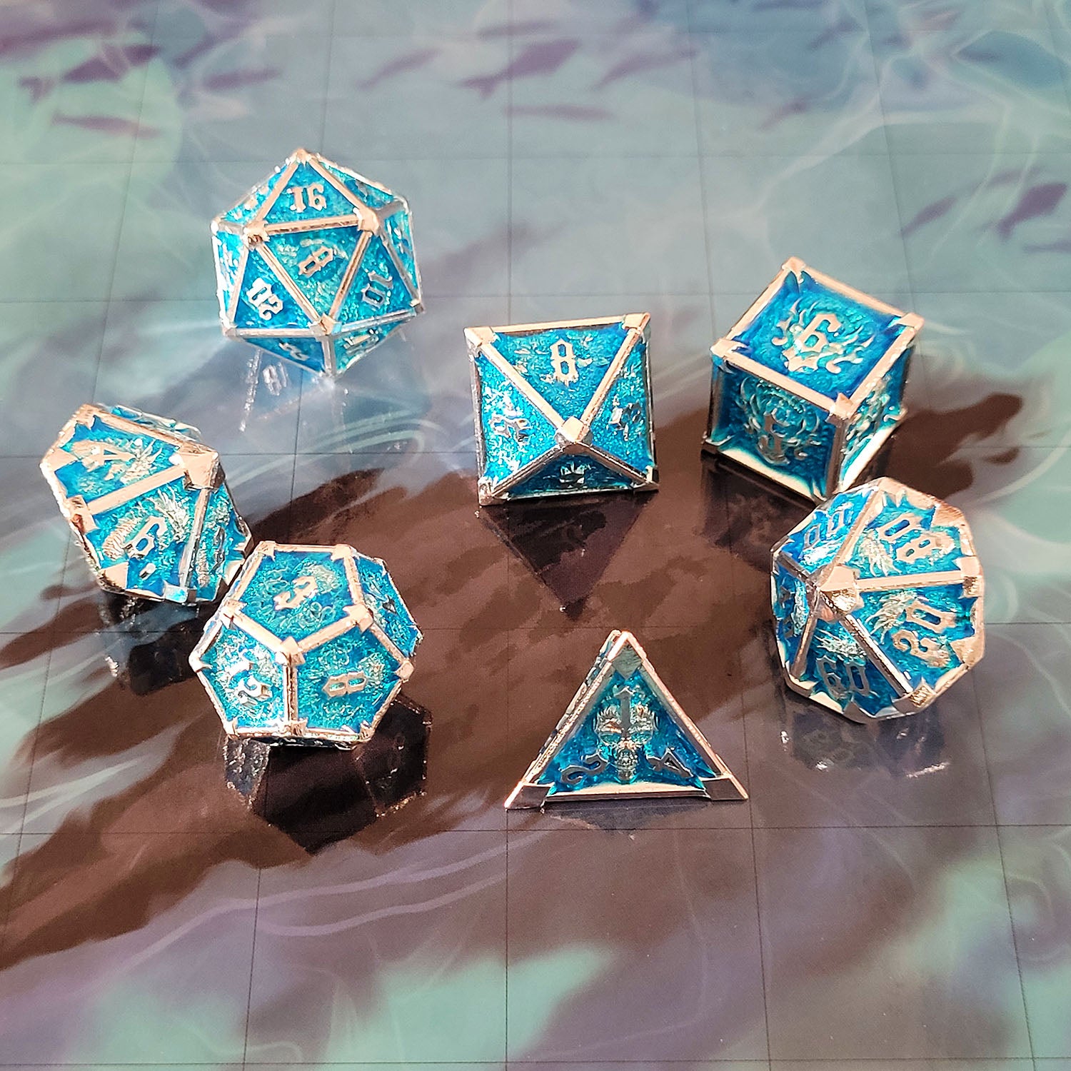 This is an environmental image of the Forged Gaming Ossuary Obscura Silver Blue Metal RPG Dice Set. The photo was taken using the Open Water Encounter Map as a background.