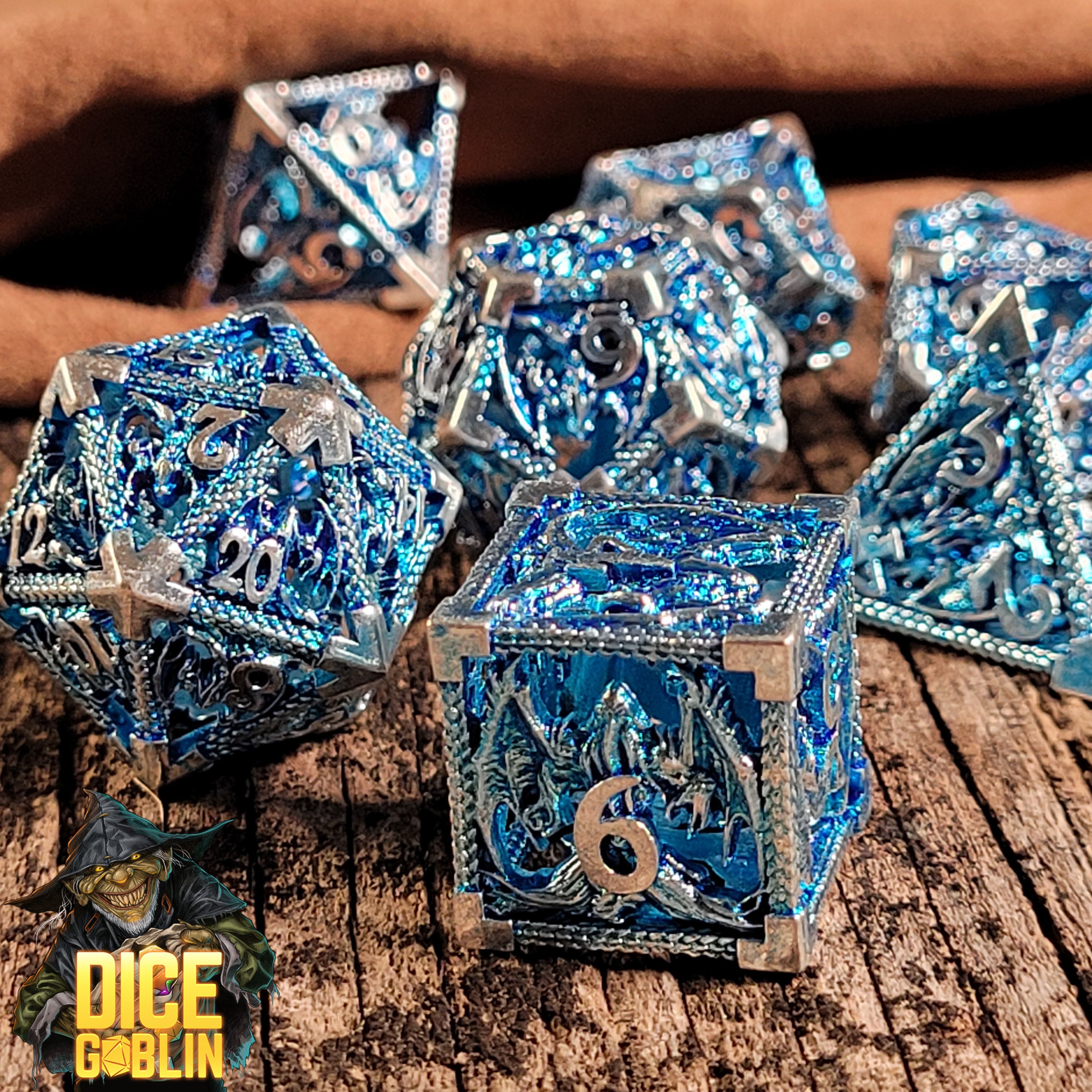 This is an environmental image of the Dice Goblin Dragon Rampant Silver Blue Hollow Metal RPG Dice Set taken on a distressed wood surface.