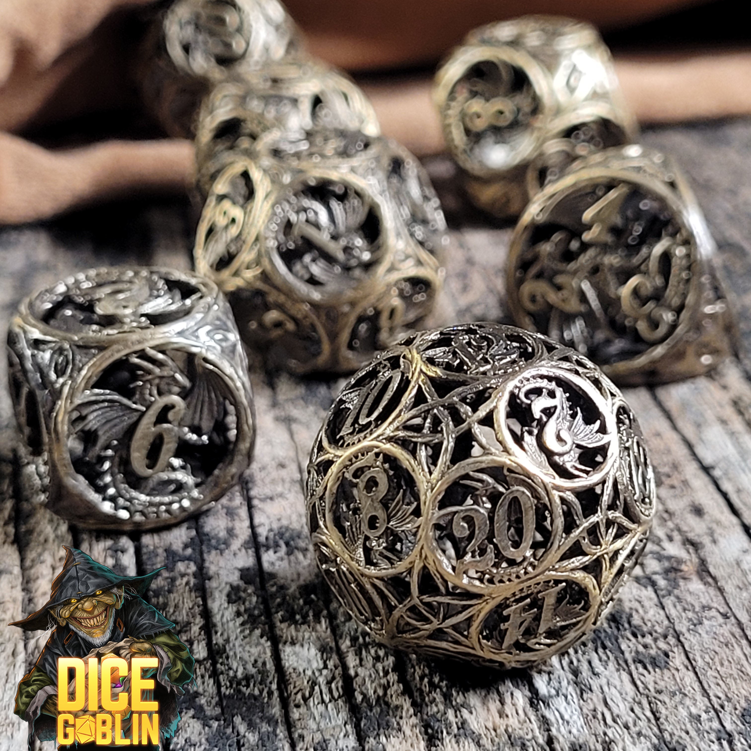 This is an environmental image of the Dice Goblin Dragon's Round Weathered Gold Metal RPG Dice Set on a distressed wood surface.