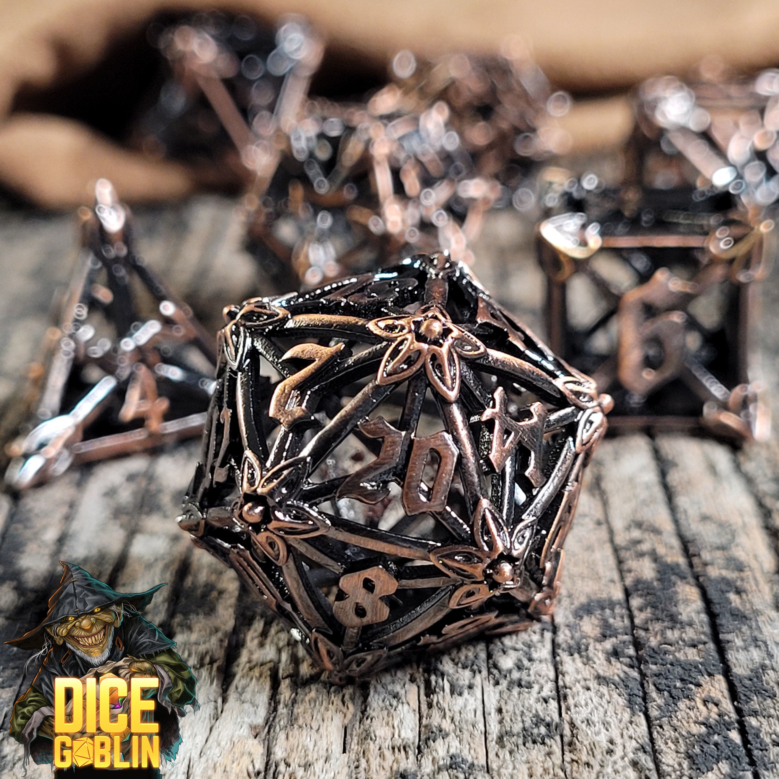 This is an environmental image of the Dice Goblin Flower Petals Copper with Dark Wash Hollow Metal RPG Dice Set on a distressed wood surface.