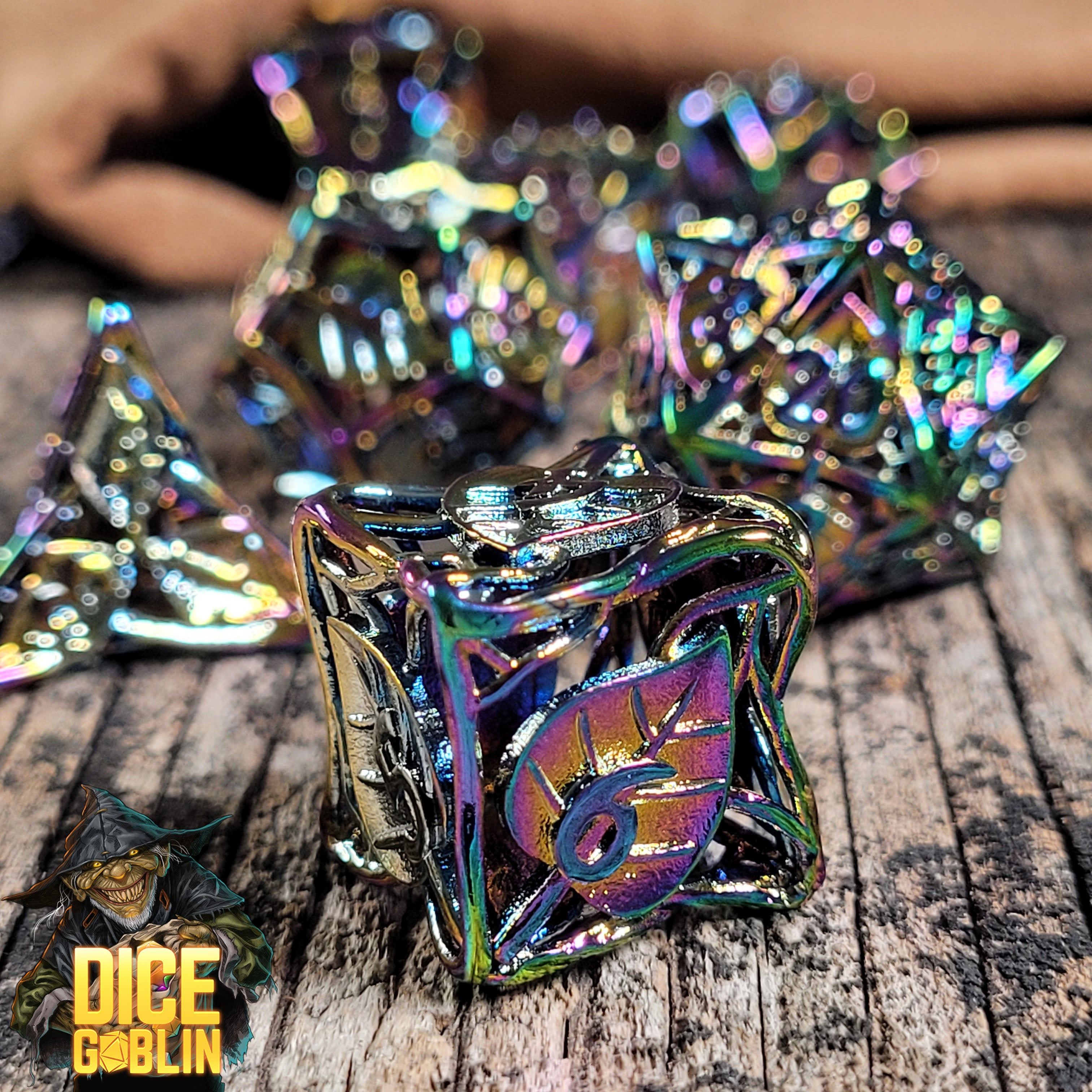 This is an Environmental image of the Dice Goblin Leaves Iridescent Hollow Metal RPG Dice Set on a distressed wood surface.