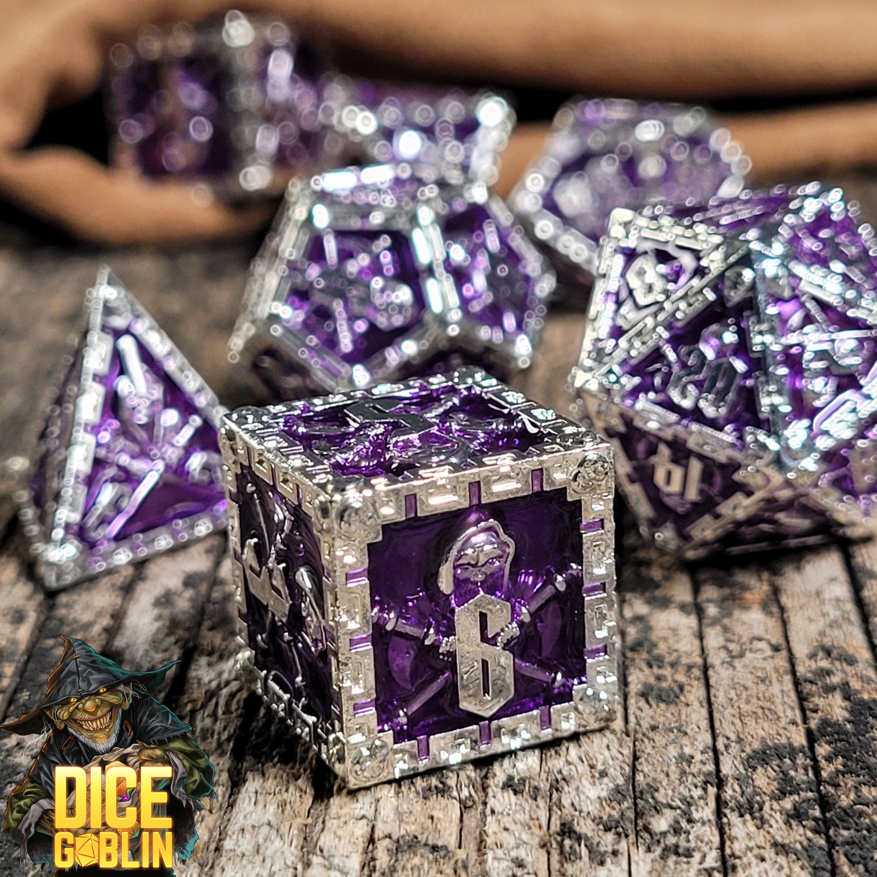 This is an environmental image of the Dice Goblin Reaper Silver with  Purple Metal RPG Dice Set on a distressed wood surface.