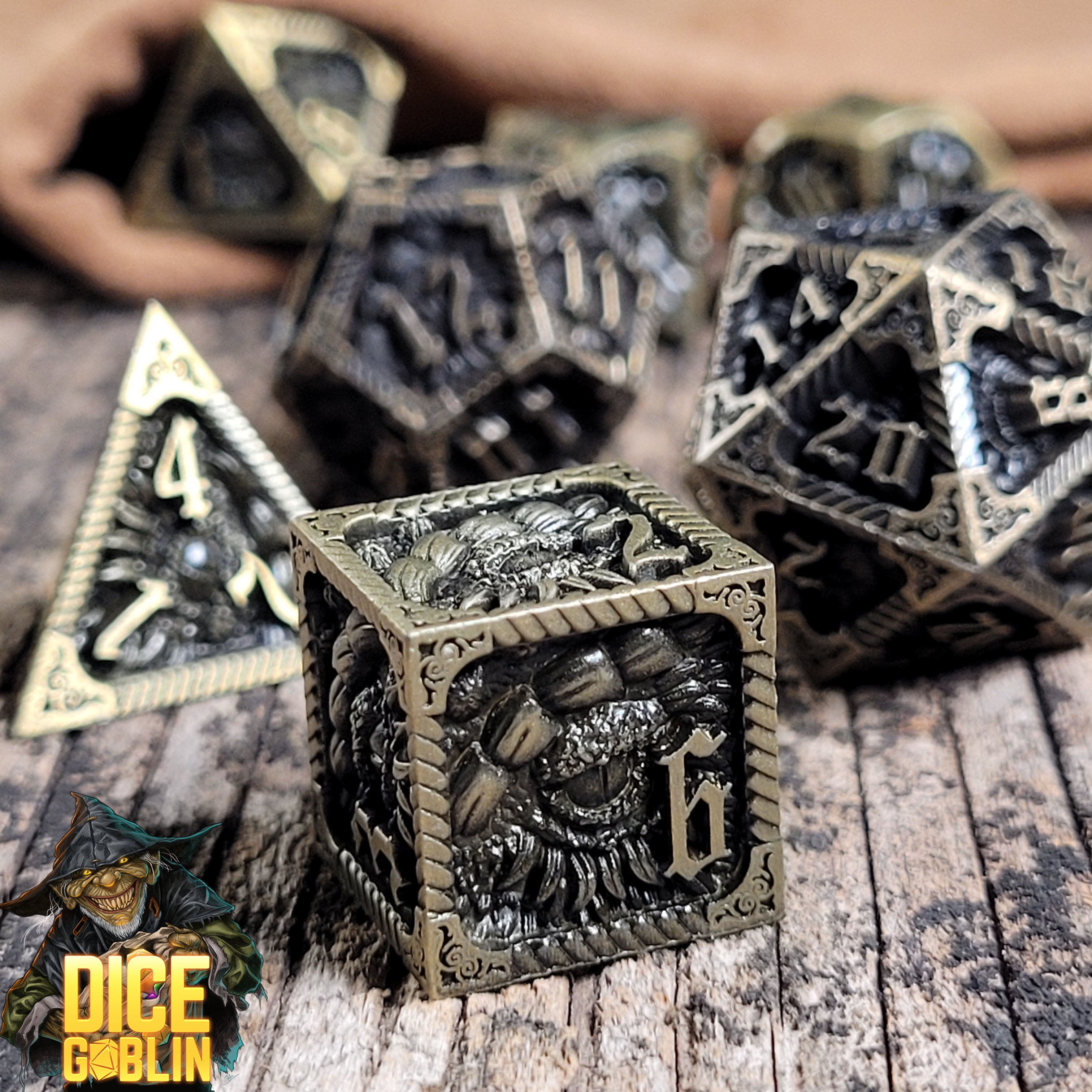 This is an environmental image of the Dice Goblin Dragon's Eye Dark Washed Gold Metal RPG Dice Set on a distressed wood surface.