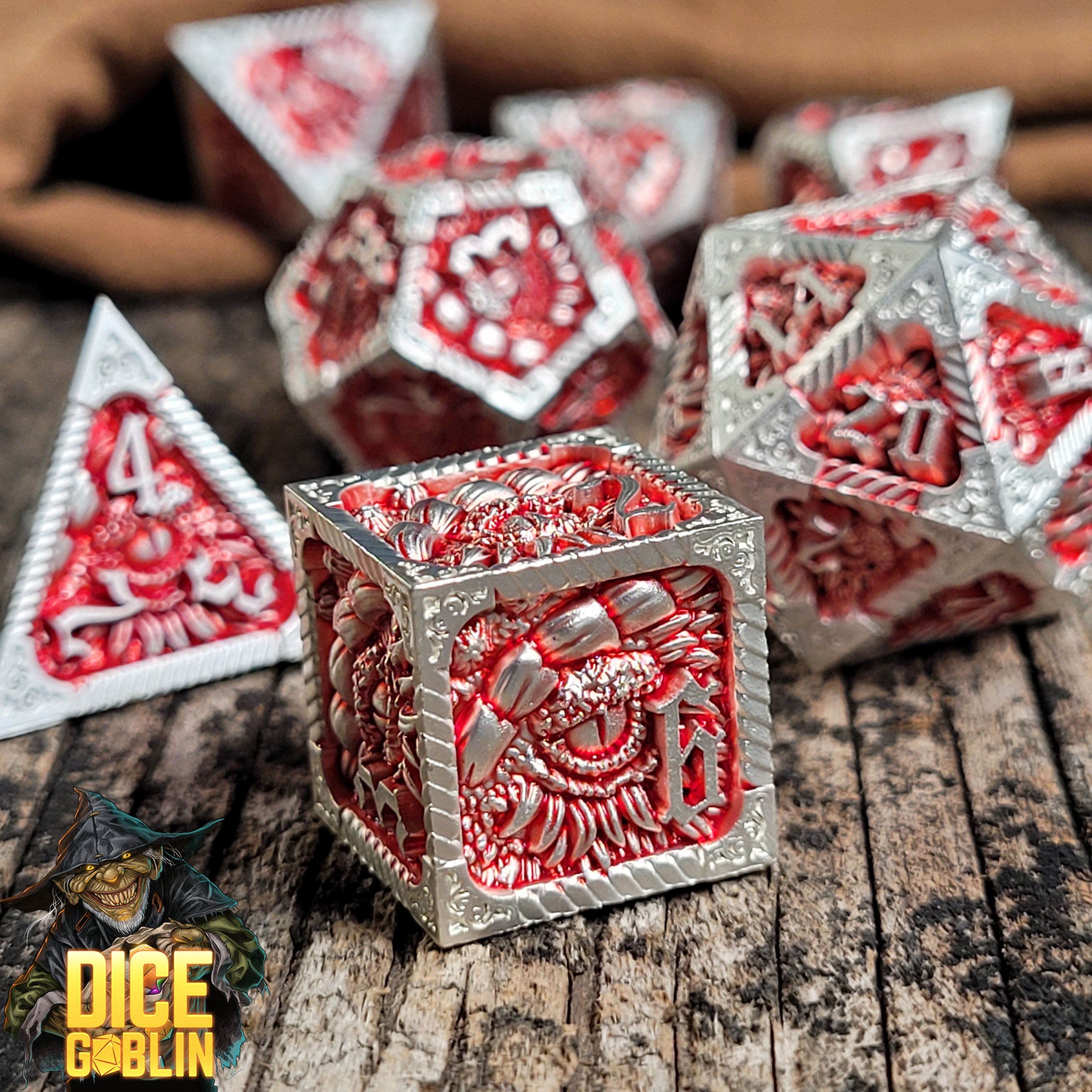 This is an environmental image of the Dice Goblin Dragon's Eye White with Red Wash Metal RPG Dice Set on a distressed wood surface.