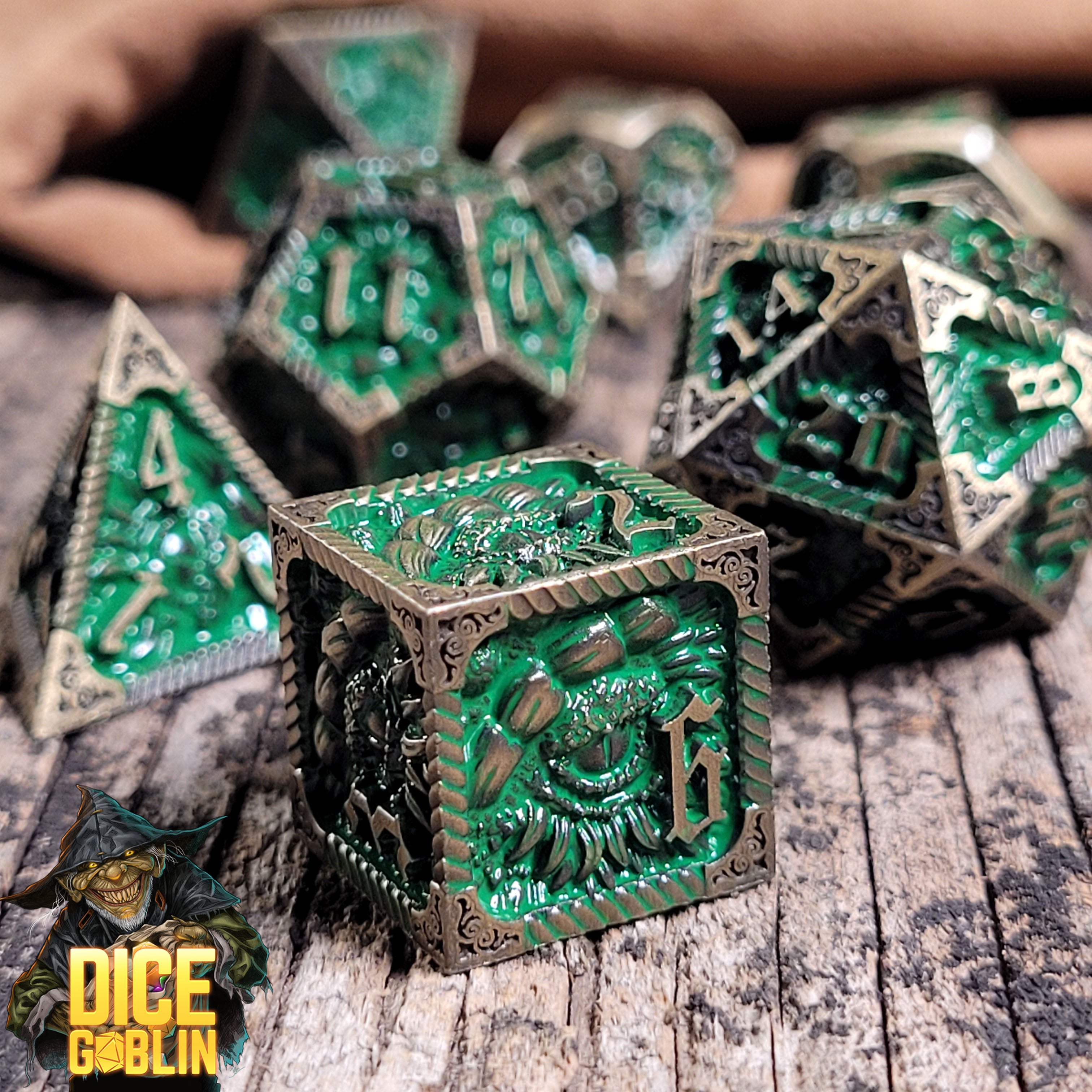 This is an environmental image of the Dice Goblin Dragon's Eye Green Washed Gold Metal RPG Dice Set on a distressed wood surface.