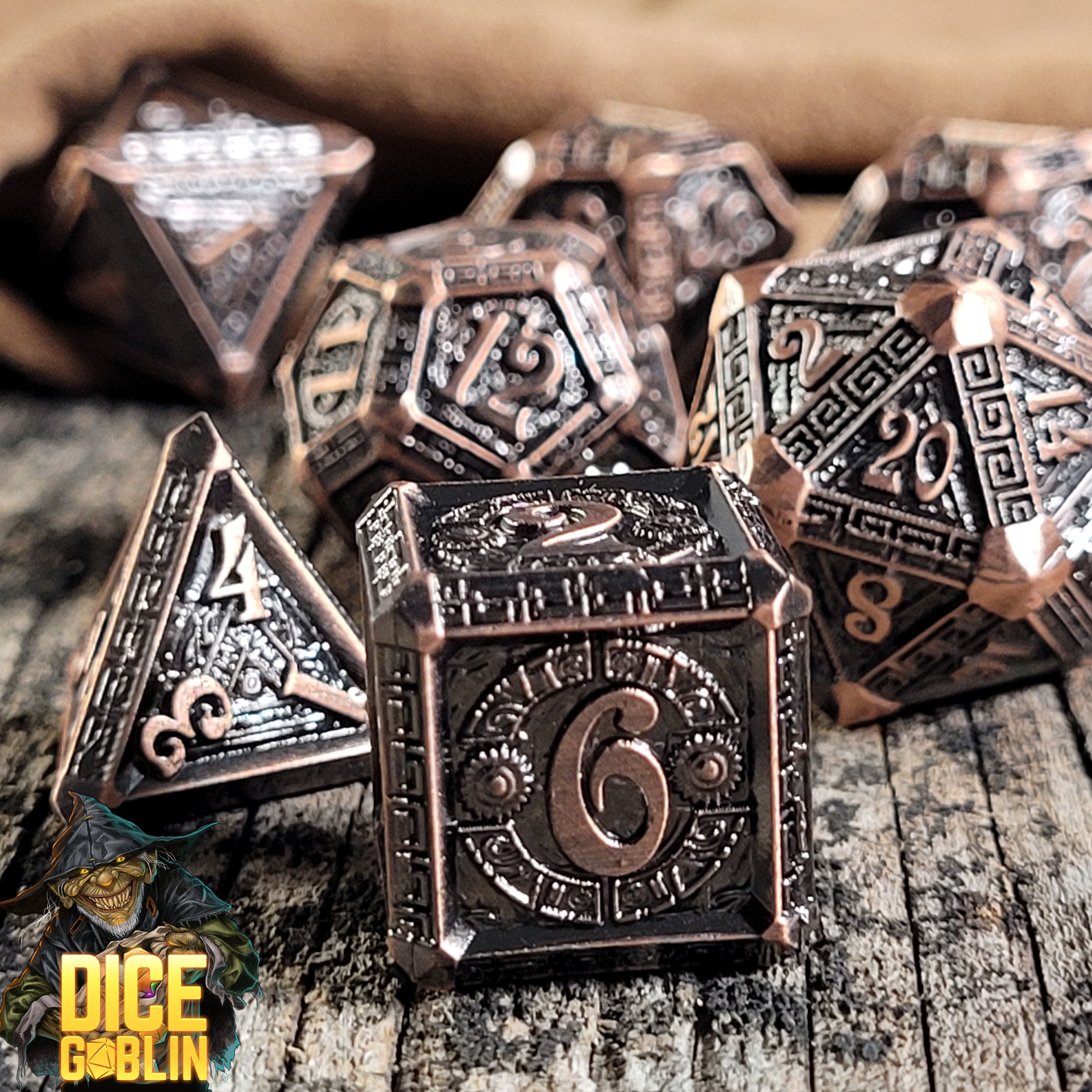 This is an environmental image of the Dice Goblin Greek Key Weathered Copper Metal RPG Dice Set on a distressed wood surface.