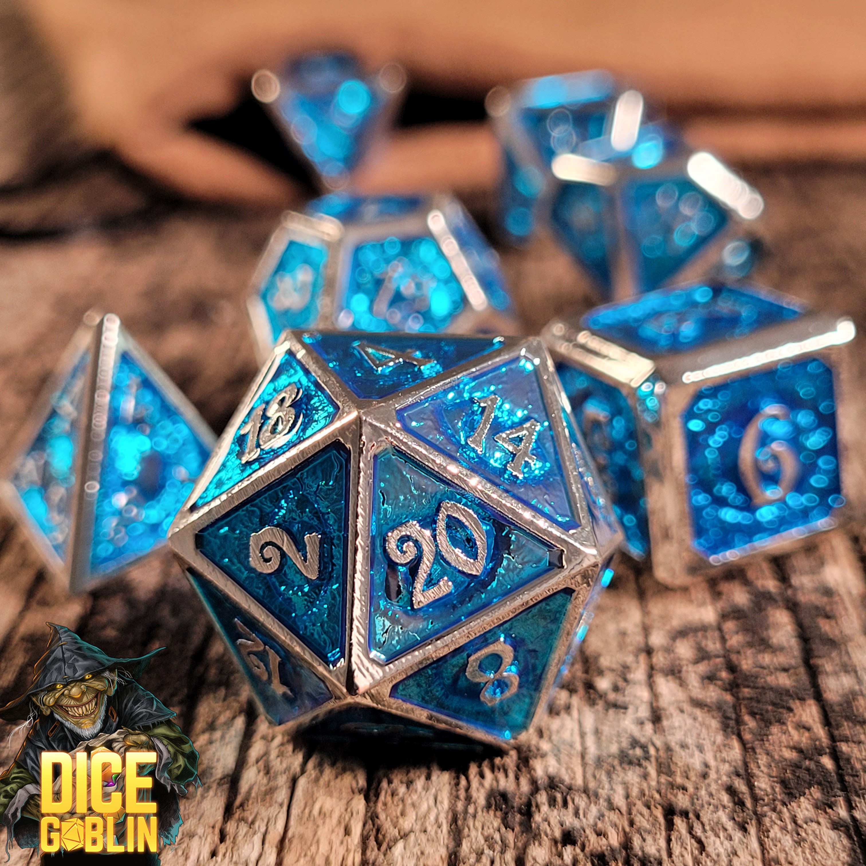 This is an environmental image of the Dice Goblin Eyes Silver with Foiled Blue Metal RPG Dice Set on a distressed wood surface.