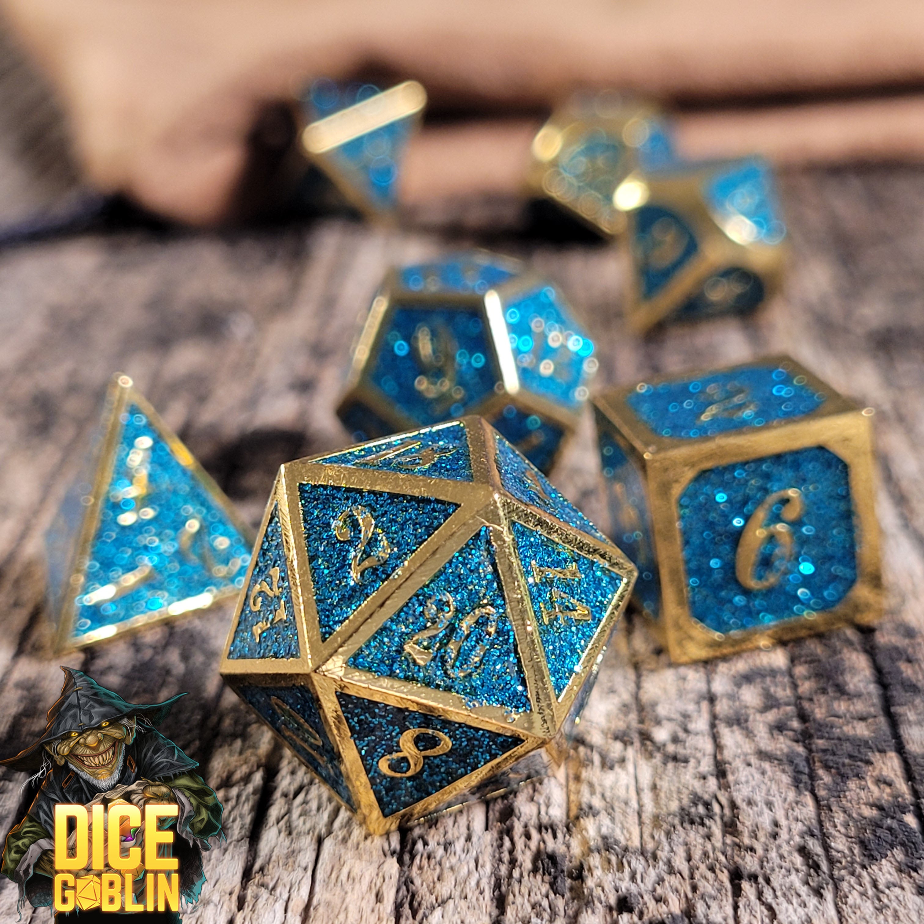 This is an environmental image of the Dice Goblin Framed Gold with Blue Glitter Metal RPG Dice Set on a distressed wood surface.