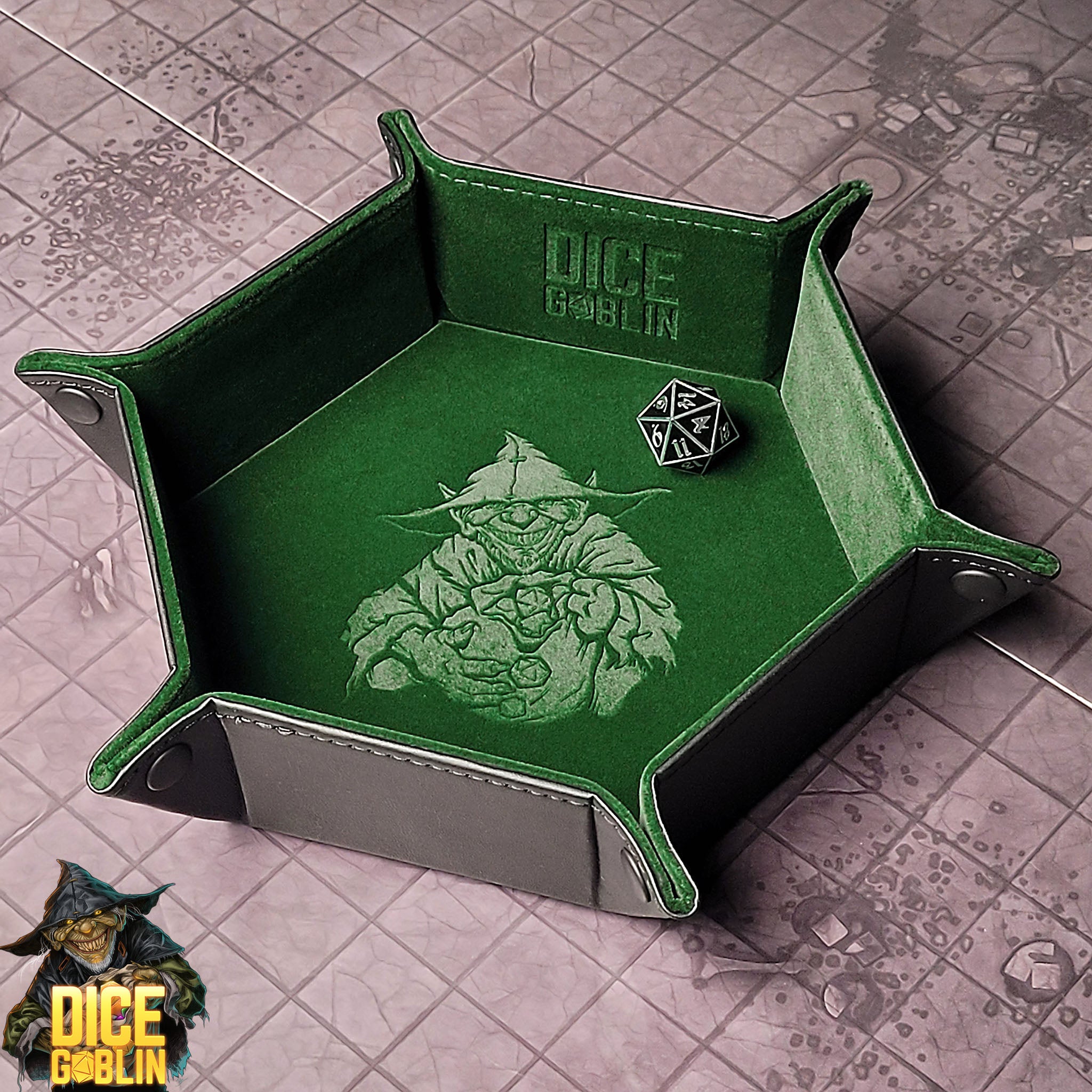 This is an environmental image of the Green colored Dice Goblin Hexagon Folding Snap Dice Tray. The image features the Dice Goblin character and logo in relief with the tray sitting on a dungeon encounter map.