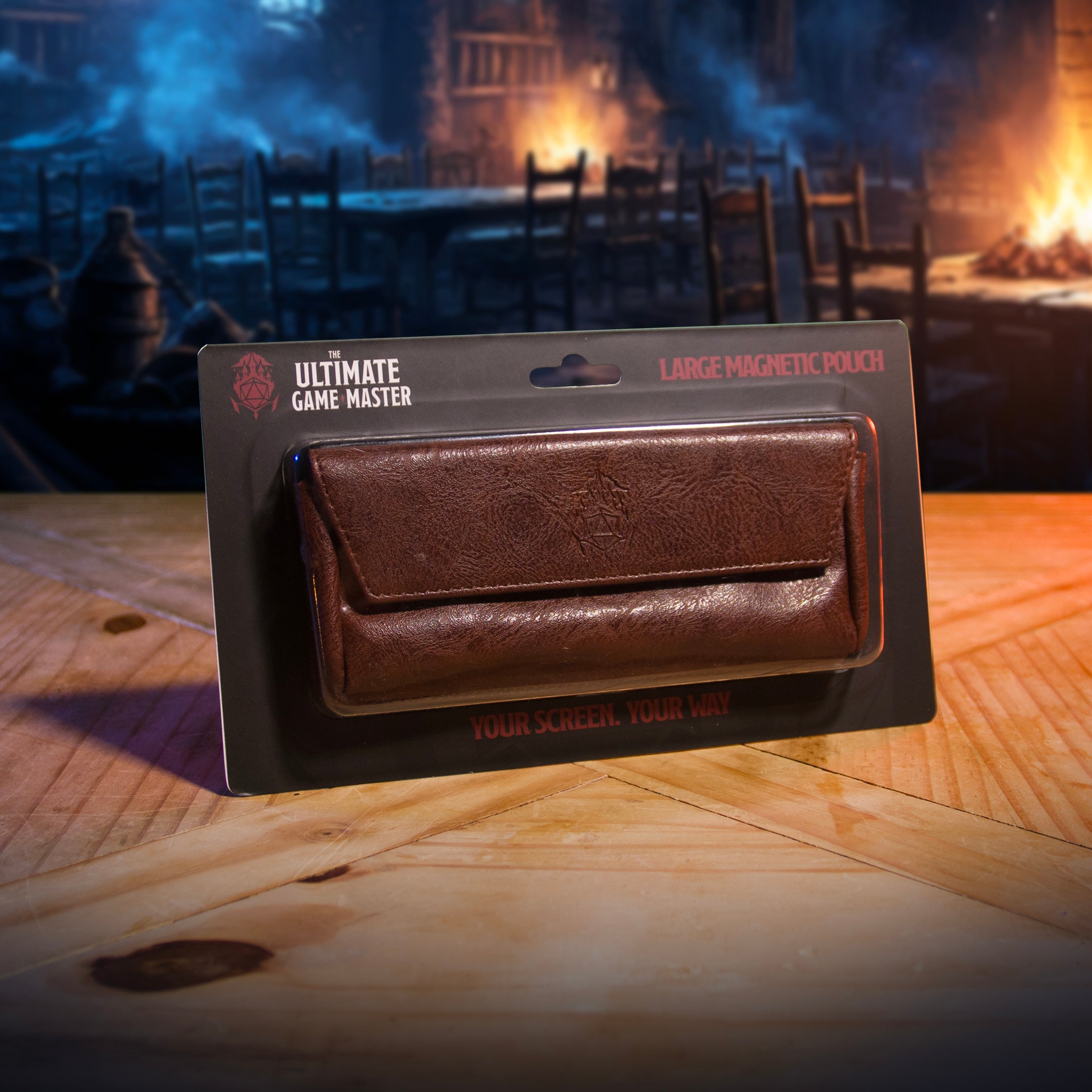 This is an environmental image of the brown version of the Ultimate Game Master Screen Large Pouch in retail packaging displayed on a table.