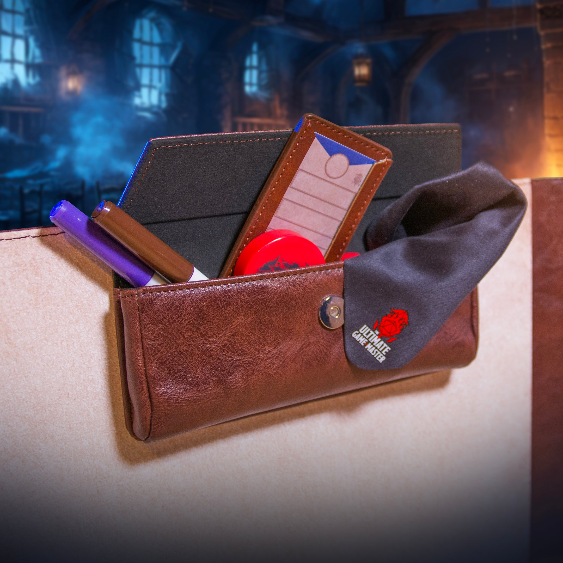 This is an environmental image of the brown version of the Ultimate Game Master Screen Large Pouch highlighting its storage functionality.