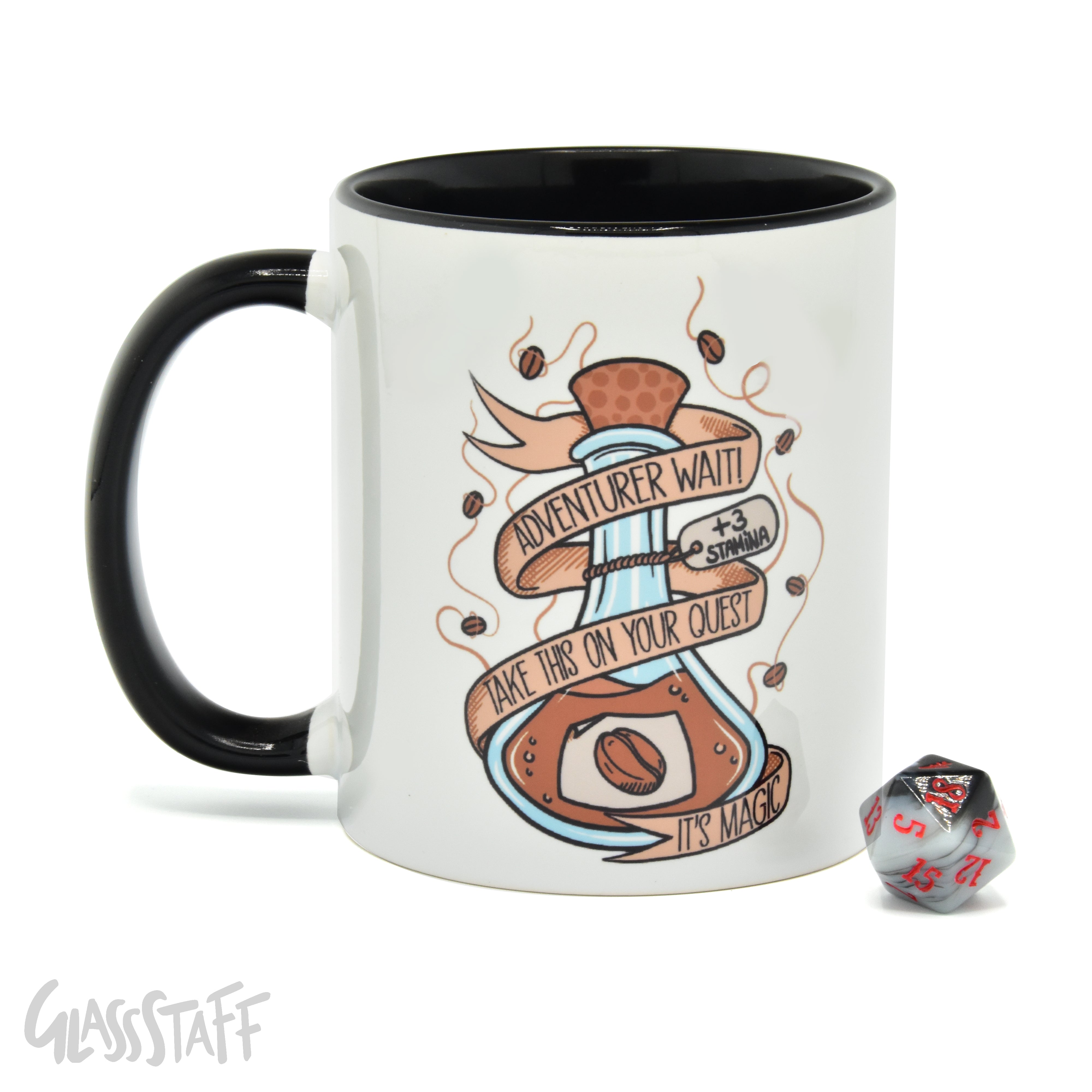 This is a white background image of the GLassStaff Magic Potion ceramic mug. It shows the white mug with a black handle, black inside, and Magic Potion design. It also shows the D20 die included with the mug.